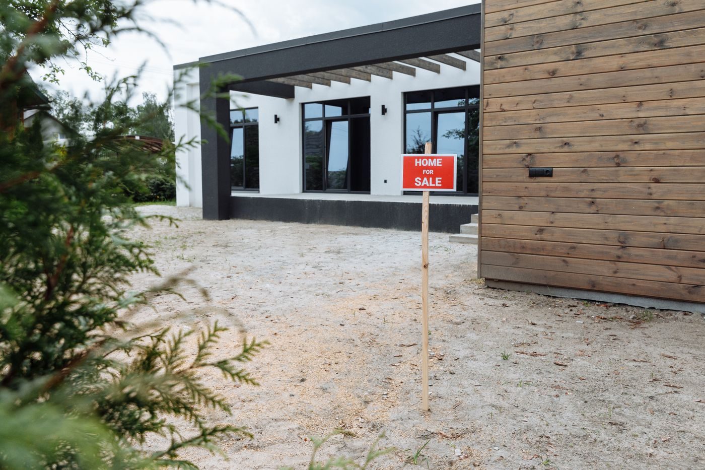 Panneau immobilier à vendre planté sur un terrain